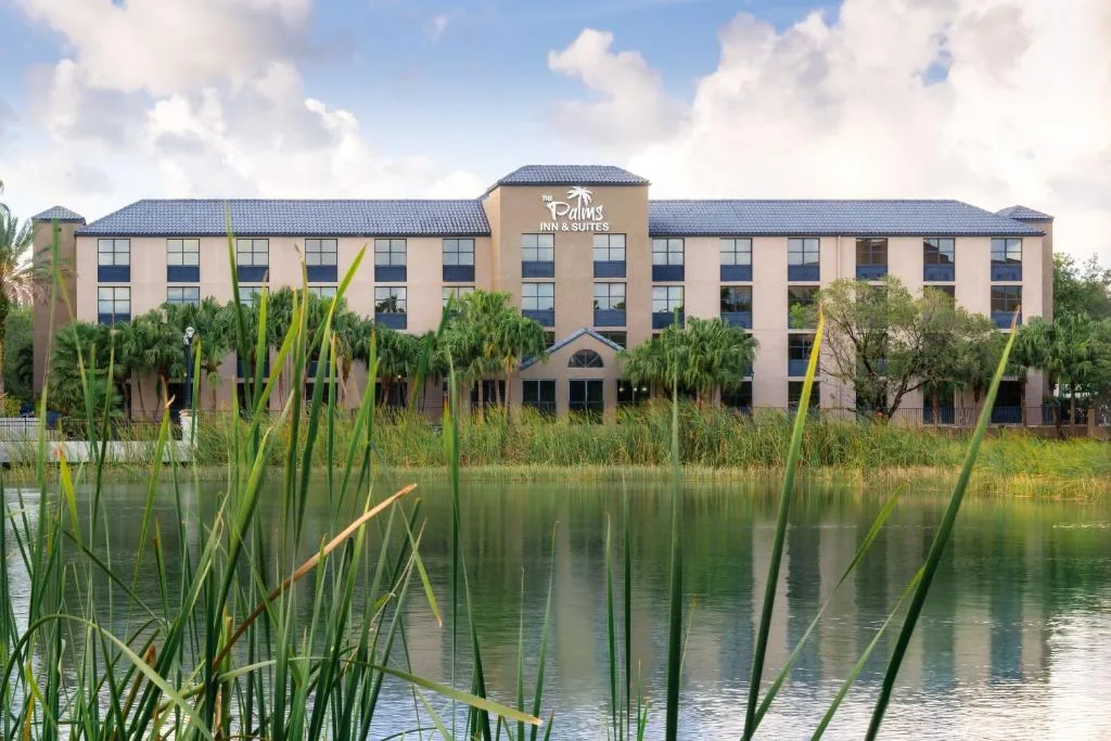 The Palms Inn and Suites exterior across the lake